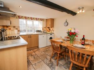 a large kitchen with a wooden table and chairs at Bicton Cottage in Acton