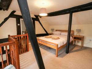 a bedroom with a four poster bed in a attic at Bicton Cottage in Acton