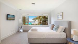 a bedroom with a large bed and a window at Unit 21 - 3 Bed Part Ocean View in Terrigal