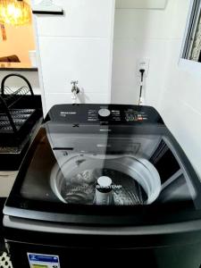um close-up de uma máquina de lavar roupa com água em Apto Executivo Ravena em Campo Grande
