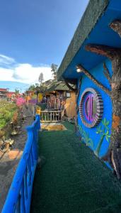 a blue house with a tree painted on it at Hotel Nature Bromo and Resort in Pasuruan