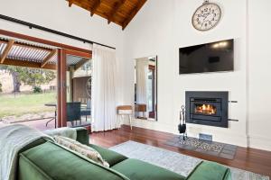 a living room with a couch and a fireplace at Grandview Accommodation - Hideaway Huts in Dawesley