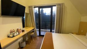 a hotel room with a bed and a desk with a television at Hotel Nature Bromo and Resort in Pasuruan