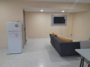 ein Wohnzimmer mit einem Sofa und einem Kühlschrank in der Unterkunft Complejo Villa Maria in Ciudad Lujan de Cuyo