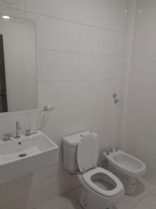 ein weißes Bad mit einem WC und einem Waschbecken in der Unterkunft Complejo Villa Maria in Ciudad Lujan de Cuyo