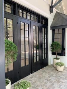 a black front door with windows and potted plants at Cottonwood Boutique Heritage Otten in Bandung