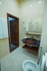 y baño con lavabo, espejo y aseo. en Ogguesto Hotel en Bakú