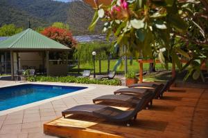 a row of lounge chairs next to a swimming pool at Harrietville Hotel Motel in Harrietville +33 photos
