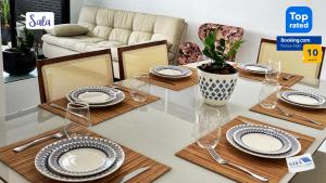 a dining room table with plates and utensils on it at Apartamento Novo - Próximo ao Shopping Jardins in Aracaju