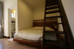 ein Schlafzimmer mit einem Etagenbett mit einer Leiter in der Unterkunft Dream Forest Villa in Renai