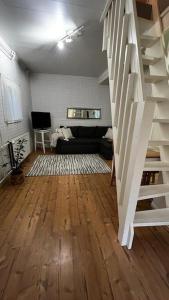 a living room with a staircase and a couch at Apartment Wanha Kartano in Kokkola