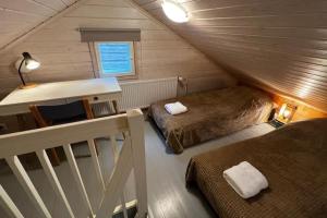 a small attic room with two beds and a desk at Apartment Wanha Kartano in Kokkola