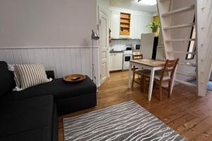 a living room with a couch and a table and a kitchen at Apartment Wanha Kartano in Kokkola