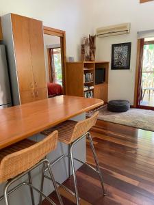 uma sala de estar com uma mesa de madeira e cadeiras em Kin Kin Cottage Retreat em Kin Kin