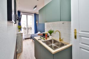 una pequeña cocina con fregadero y sofá en Apartments WS Tour Eiffel - Laos en París
