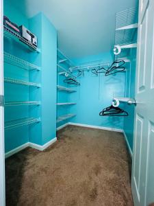 um closet azul com prateleiras e uma porta em Private quiet room with shared Bathroom,kitchen,living and dining area em Clinton