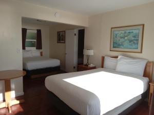 Postel nebo postele na pokoji v ubytování Blue Coast Inn & Suites