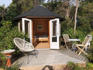 a gazebo with chairs and a table on a deck at La Casita Waiheke in Oneroa