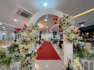 une allée de mariage avec des fleurs et un tapis rouge dans l'établissement DSH Hotel, à Kuantan