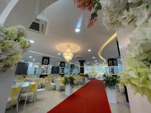 um salão de banquetes com mesas, cadeiras e flores em DSH Hotel em Kuantan