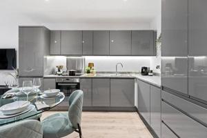 a kitchen with stainless steel appliances and a glass table at Luxury Modern, One bedroom Flat in Olton