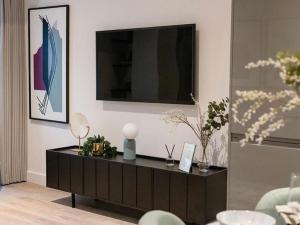 a living room with a black cabinet with a television on it at Luxury Modern, One bedroom Flat in Olton