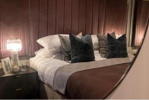 ein Schlafzimmer mit einem Bett mit Kissen und einem Spiegel in der Unterkunft Luxury Modern, One bedroom Flat in Olton
