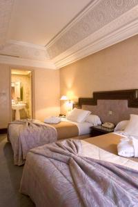 マラケシュにあるNassim Hôtelのベッド2台とバスルームが備わるホテルルームです。