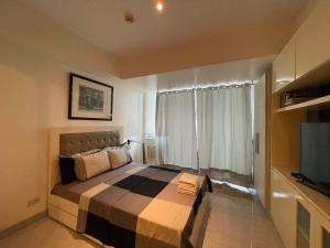 um quarto com uma cama grande e uma televisão em Azure Urban Resort with WIFI and Netflix em Manila