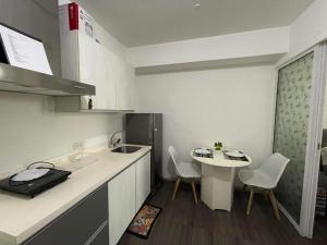 uma pequena cozinha com um lavatório e uma mesa em Azure Urban Resort with WIFI and Netflix em Manila
