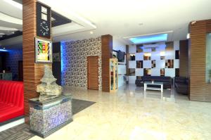 a lobby with a red couch and a red chair at Hip Hope Hotel Banda Aceh in Banda Aceh