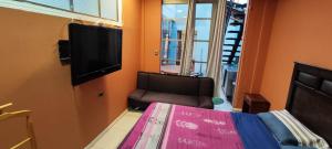 um quarto com uma cama e uma cadeira e uma televisão de ecrã plano em Casa de Verano em Iquique