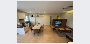 eine Küche und ein Wohnzimmer mit einem Tisch und Stühlen in der Unterkunft ARU SUITES 3BR Nilam Residence INFINITY POOL in Kota Kinabalu
