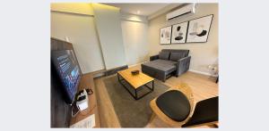 ein Wohnzimmer mit einem Sofa und einem TV in der Unterkunft ARU SUITES 3BR Nilam Residence INFINITY POOL in Kota Kinabalu