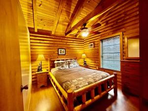 a bedroom with a bed in a log cabin at Good Life Cabin 2 in Bryson City
