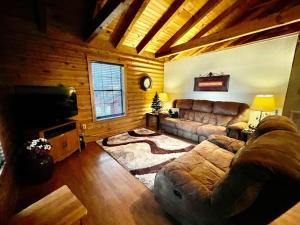 a living room with a couch and a flat screen tv at Good Life Cabin 2 in Bryson City