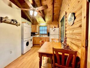 a kitchen with a table and a white refrigerator at Good Life Cabin 2 in Bryson City