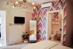 a bedroom with a colorful accent wall and a bathroom at The Oleander Hotel Room Number 1 in Galveston