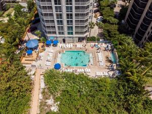 een uitzicht over een zwembad met stoelen en parasols bij Immaculate Direct Gulf Front 3 Bedroom Condo - Gullwing 505 condo in Fort Myers Beach