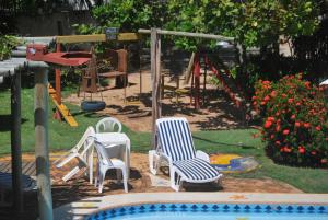 un patio con sillas y un parque infantil con tobogán en Pousada Agua Marinha en Imbassai