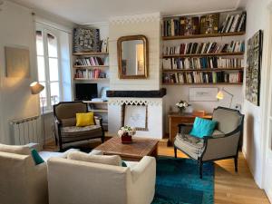 salon z 2 krzesłami i kominkiem w obiekcie Appartement élégant 3* au coeur de Le Palais, 2 chambres, proche commerces et plage - FR-1-418-197 w mieście Le Palais