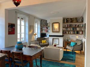 salon ze stołem i krzesłami oraz kominkiem w obiekcie Appartement élégant 3* au coeur de Le Palais, 2 chambres, proche commerces et plage - FR-1-418-197 w mieście Le Palais