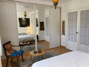 sypialnia z lustrem, łóżkiem i krzesłem w obiekcie Appartement élégant 3* au coeur de Le Palais, 2 chambres, proche commerces et plage - FR-1-418-197 w mieście Le Palais