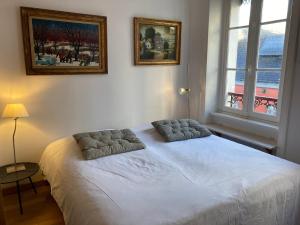 sypialnia z białym łóżkiem z 2 poduszkami w obiekcie Appartement élégant 3* au coeur de Le Palais, 2 chambres, proche commerces et plage - FR-1-418-197 w mieście Le Palais
