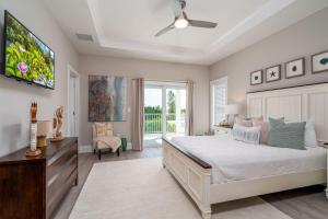 Un dormitorio con una cama grande y un televisor. en 661 Estero Blvd "Beach to Bay" home, en Fort Myers Beach