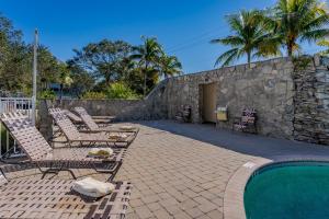 a patio with chairs and a swimming pool at -The Bonita Paddle Efficiency- Your Home Away From Home in Paradise condo in Bonita Springs
