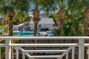 uma vista para a piscina a partir da varanda de uma casa com palmeiras em - The Bonita Paddle A202 - Beautiful Bonita Springs Condo with Mother In Law Suite! condo em Bonita Springs