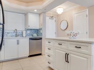 フォートマイヤーズビーチにあるTwo-Bedroom Apartmentの白いキャビネットとシンクのあるキッチン +13枚の写真