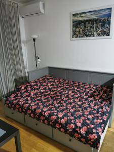 ein Schlafzimmer mit einem Bett mit einer Blumendecke in der Unterkunft Studio Charlie Aviv Park Zvezdara in Belgrad