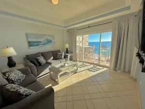 a living room with a couch and a table at Spectacular 2 Bedroom Condo on Sandy Beach at Las Palmas Resort B-705 condo in Puerto Peñasco